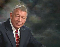 ron dart in a studio portrait. he is an older white man with short gray hair