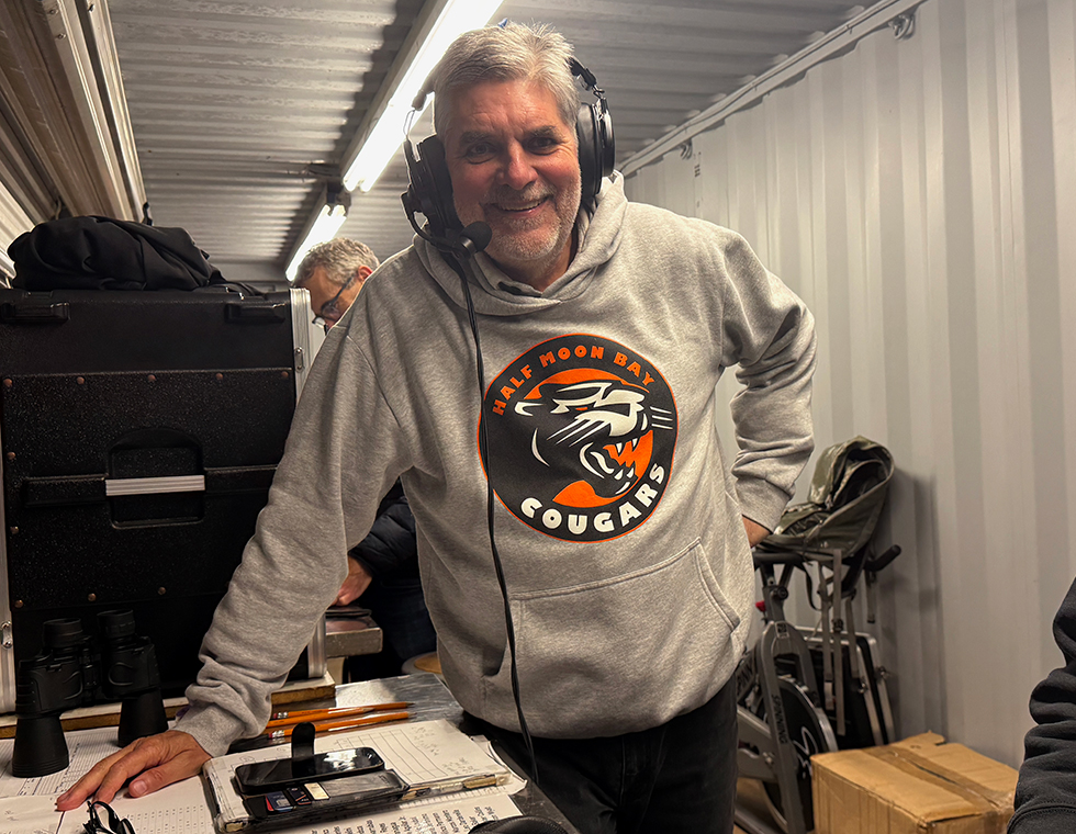announcer pat olson at a game. he is wearing a headset with mic